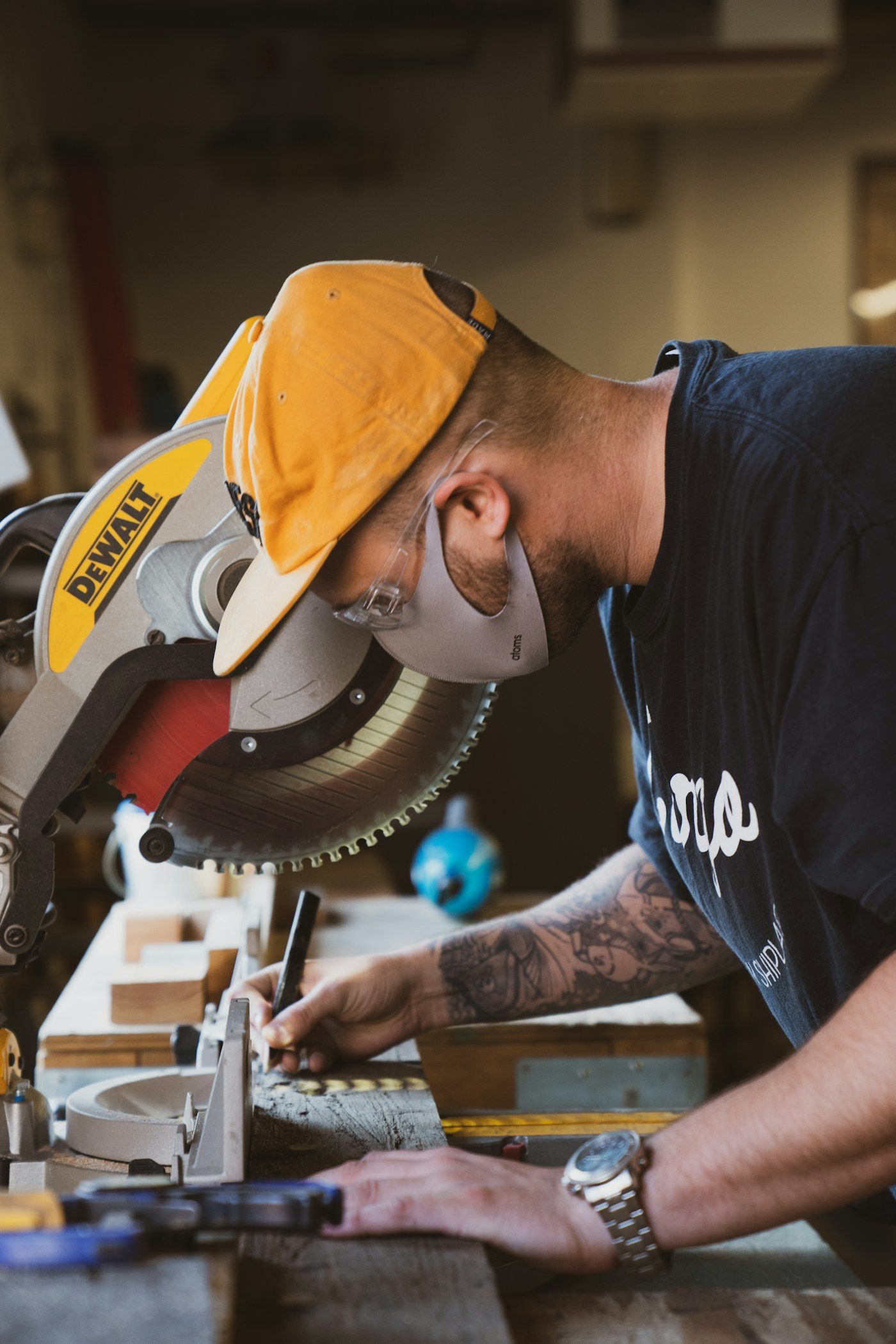 Tradie working at a mitre saw in a workshop